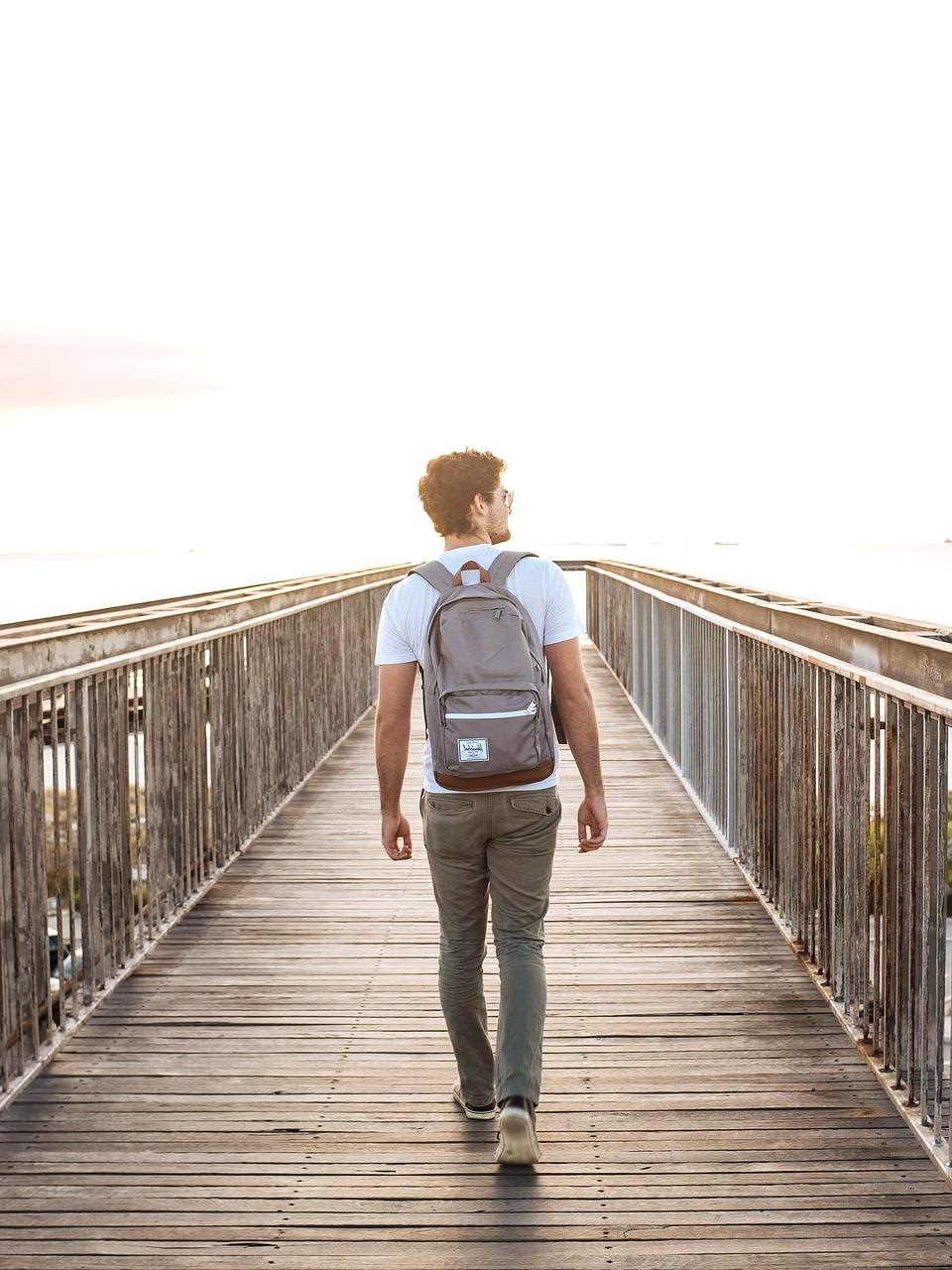 Solo traveler walking down a colorful urban street with backpack