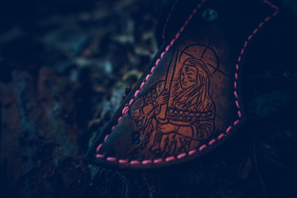 Small GPS tracking device attached to backpack with smartphone showing location